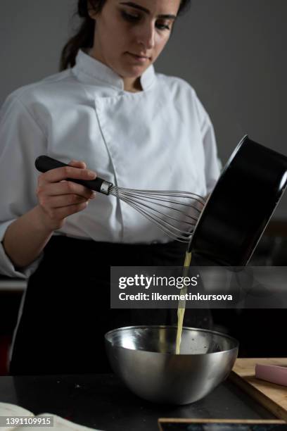 female confectioner preparing chocolate sauce - hand holding whisk stock pictures, royalty-free photos & images