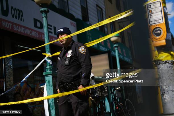 Police gather at the scene of a shooting at the 36 St subway station on April 12, 2022 in the Brooklyn borough of New York City. According to...