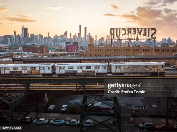 train passing in queens with the view on manhattan skyline - queens - new york city stock pictures, royalty-free photos & images