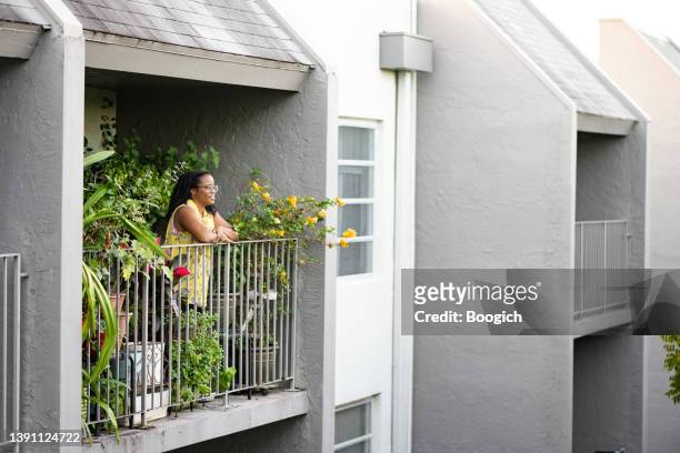 vraie femme afro-américaine à la maison avec des plantes - real people lifestyle photos et images de collection