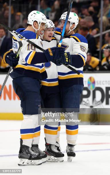 Torey Krug of the St. Louis Blues, center, celebrates with Brayden Schenn and David Perron after scoring a goal against the Boston Bruins during the...