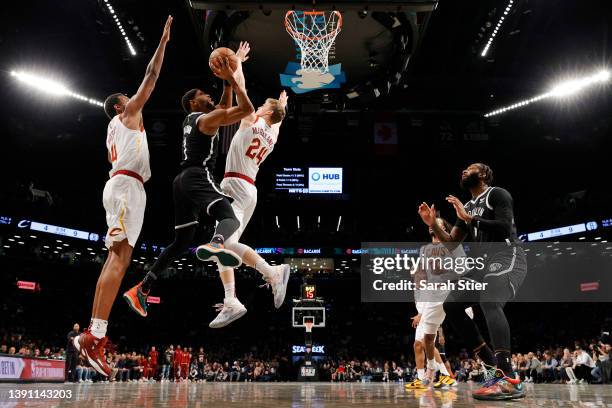 Bruce Brown of the Brooklyn Nets goes to the basket as Evan Mobley and Lauri Markkanen of the Cleveland Cavaliers defend during the Eastern...