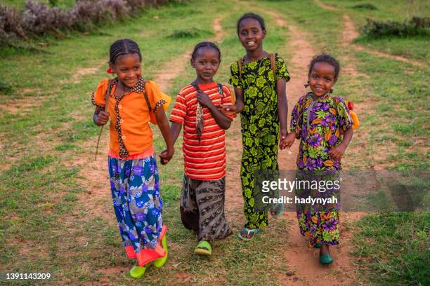 african girls carrying water from the well, ethiopia, africa - african girl drinking water stockfoto's en -beelden