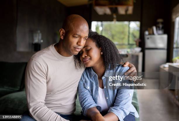 loving husband consoling his sad wife crying at home - crying sad african woman stock pictures, royalty-free photos & images