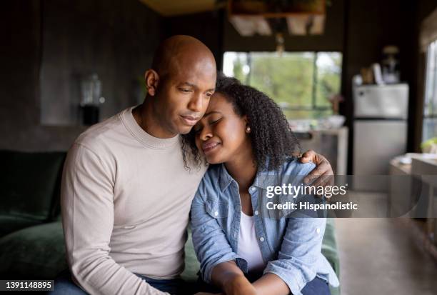 loving husband consoling his sad wife crying at home - grief 個照片及圖片檔