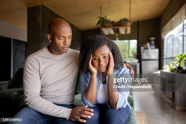 loving husband consoling his sad wife at home - unhappy husband stock pictures, royalty-free photos & images