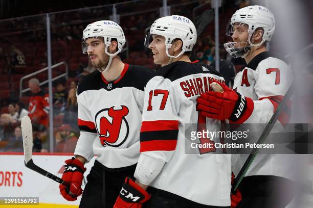 Yegor Sharangovich of the New Jersey Devils is congratulated by Kevin Bahl and Dougie Hamilton after scoring a goal against the Arizona Coyotes...