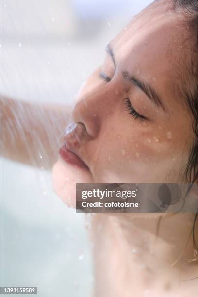 mujer bajo corriente de agua y relajándose mientras se ducha en la bañera - stream body of water fotografías e imágenes de stock
