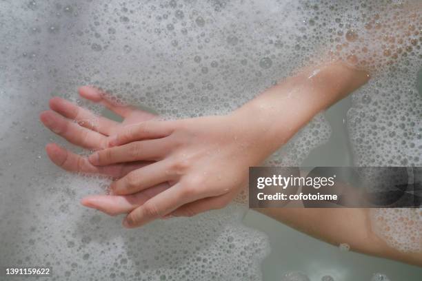 close up woman hand with fizzy bubble in bathtub - bath bomb stock pictures, royalty-free photos & images