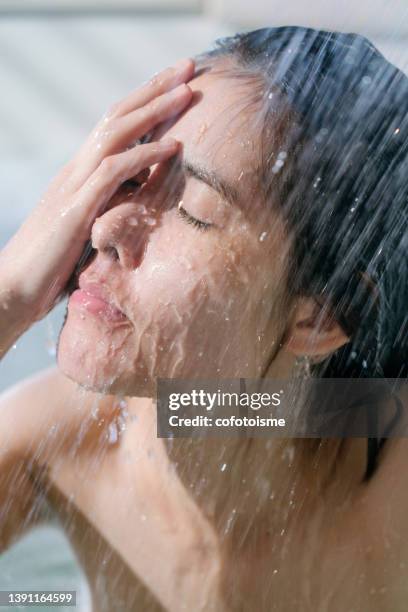 mujer bajo corriente de agua y relajándose mientras se ducha en la bañera - stream body of water fotografías e imágenes de stock