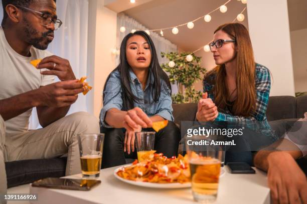 diverse friends hanging out eating snacks - mexican food party stock pictures, royalty-free photos & images