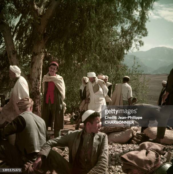 Scène de marché avec des hommes kabyles en tenue traditionnelle en 1957 dans le village des Ouadhia en Kabylie en Algérie.