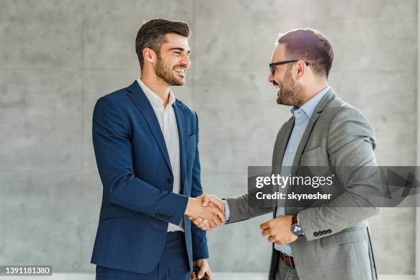 gli uomini d'affari felici hanno raggiunto un accordo in ufficio. - stringersi la mano foto e immagini stock