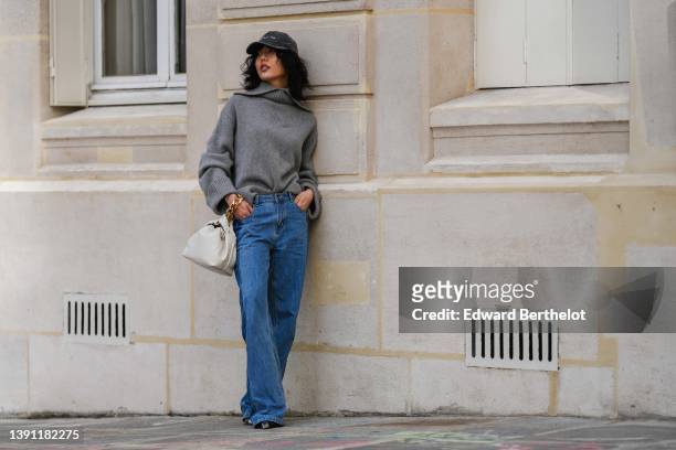 Xiayan wears a black faded denim cap with embroidered white "Bad Hair Day" slogan, a gray wool high neck oversized pullover, high waist blue large...