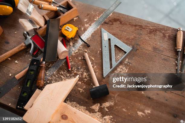 carpenter tools,hammer,meter,nails,shavings, and chisel over wood table - construction equipment stockfoto's en -beelden