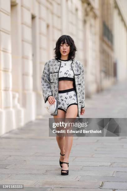 Xiayan wears a white with black and white tweed and sequined Chanel logo pattern cropped t-shirt from Chanel, matching white with black and white...