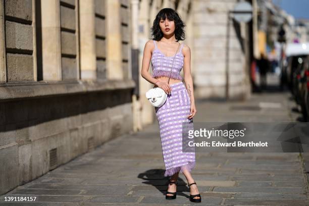 Xiayan wears a pale purple and white checkered print pattern with feathers embroidered borders V-neck / cropped tank-top, matching pale purple and...