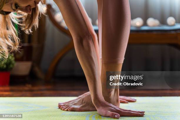 cropped shot of a fit woman stretching during her workout routine at home - touching toes stock pictures, royalty-free photos & images