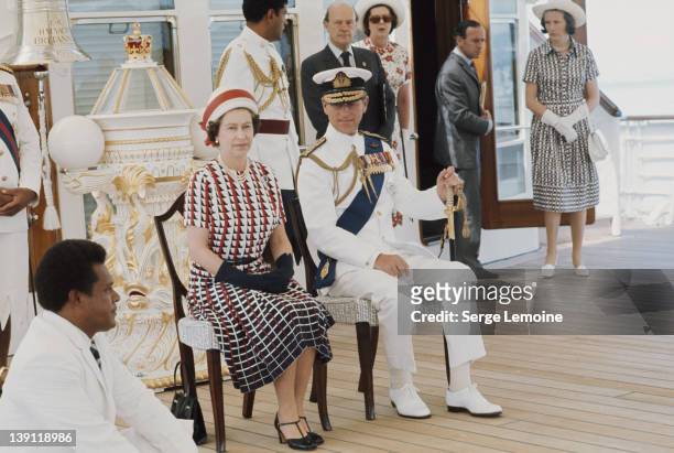 Queen Elizabeth II and Prince Philip watch the entertainments aboard the Royal Yacht 'Britannia', upon their arrival in Fiji during their royal tour,...