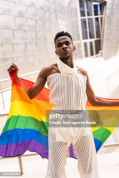 portrait of a model man of black ethnicity with the lgbt flag and in a fashionable outfit, pride day, rainbow flag. protests for freedom! we want to be free!, concept of the lgbt community - black transgender 個照片及圖片檔