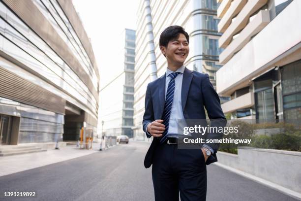 asian businessmen stood on the street and looked into the distance - three quarter length stock pictures, royalty-free photos & images