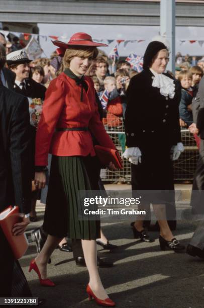 British Royals Diana, Princess of Wales , wearing a red suit with a black pleated skirt designed by Donald Campbell and a John Boyd hat, greets well...