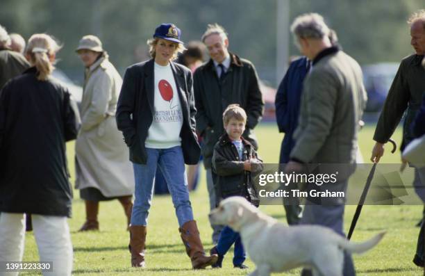 British Royal Diana, Princess of Wales , wearing a British Lung Foundation sweatshirt, with a baseball cap, jeans and brown boots, and her son Prince...