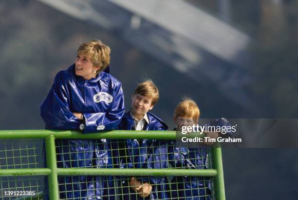 British Royal Diana, Princess of Wales and her sons, Prince William and Prince Harry, all wearing blue waterproof ponchos, during a private ride...