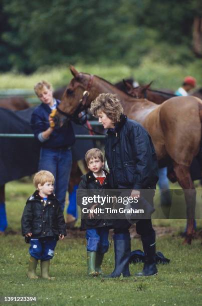 British Royal Prince Harry and his brother Prince William, both wearing waxed jackets and wellington boots, with their nanny Ruth Wallace at...