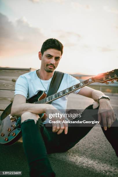 bearded male guitarist enjoying sunset and making music on highway - musician male energy imagens e fotografias de stock