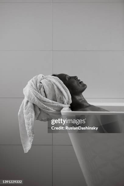 relaxed woman in bathtub. - monochrome bathroom stock pictures, royalty-free photos & images