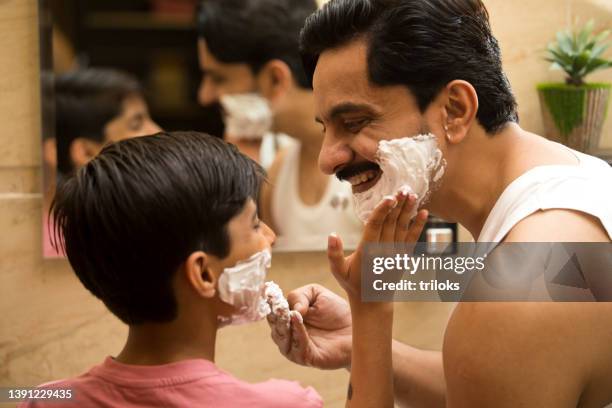 father and son applying shaving cream on face - shaving beard stock pictures, royalty-free photos & images