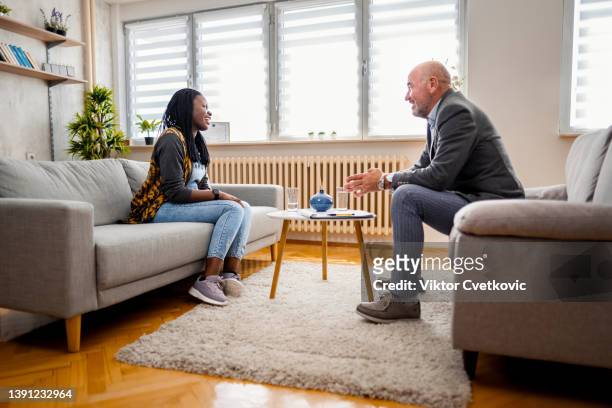 mujer negra explicando sus problemas en una sesión de terapia en la oficina del psicólogo - psychiatrists couch fotografías e imágenes de stock
