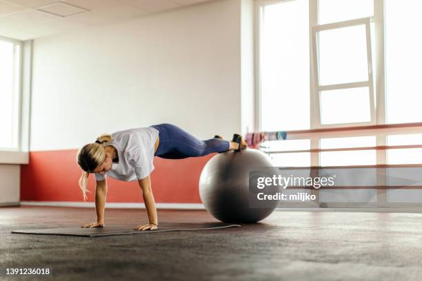 young woman exercising in plank position in gym - fitness ball stock pictures, royalty-free photos & images