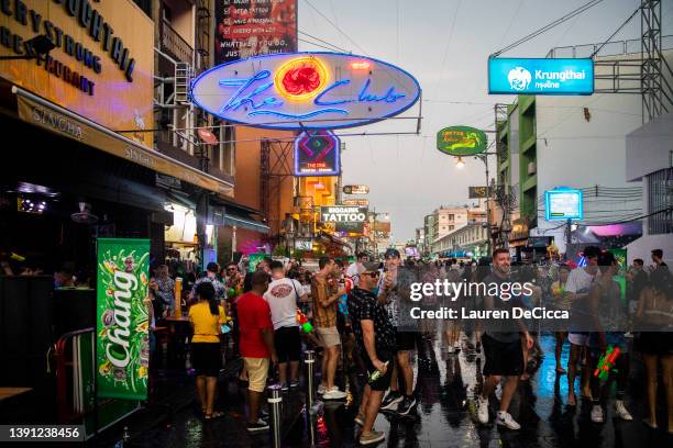 Thai tourists and locals celebrate Songkran by spraying each other with water guns and partying on Khaosan Road on April 13, 2022 in Bangkok,...