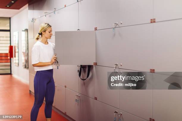 young woman preparing and dressing up for training in gym - locker stock pictures, royalty-free photos & images