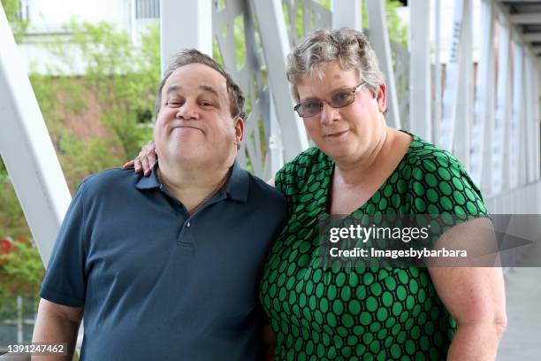 mature adult female sits next to her autistic brother - autism adult stock pictures, royalty-free photos & images