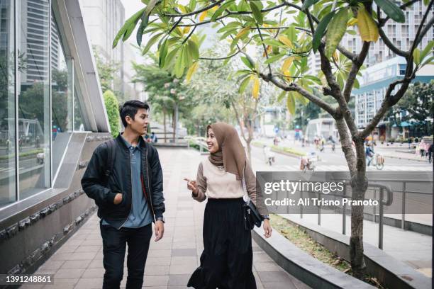 young hijab girl and young man, bestie, walking together - ジャカルタ ストックフォトと画像