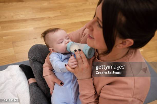 feeding baby boy milk bottle - child yoga elevated view stock pictures, royalty-free photos & images