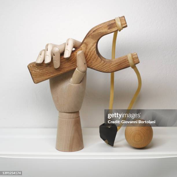 hand with slingshot and stone, wooden mannequin - mannequin arm stock pictures, royalty-free photos & images