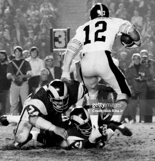 Pittsburgh Steelers QB Terry Bradshaw is swarmed by the arms of Los Angeles Rams Cody Jones and Merlin Olsen during game action of Los Angeles Rams...