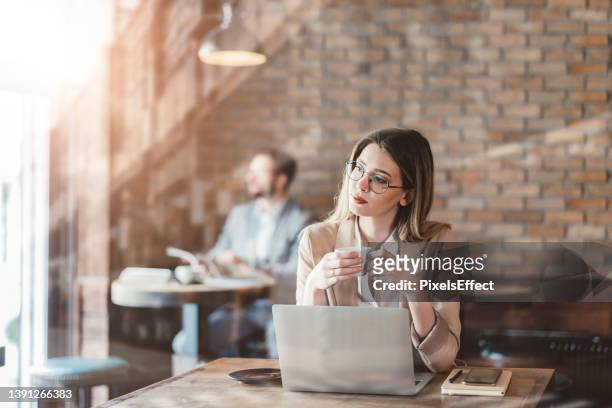 businesswoman drinking coffee in a coffee shop - enjoying coffee cafe morning light stock pictures, royalty-free photos & images
