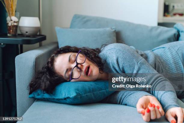 woman sleep at home on a sofa - sleeping stock-fotos und bilder