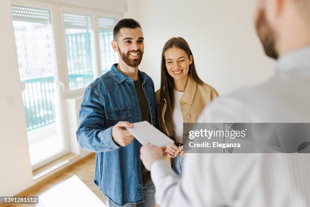 immobilienmakler, der dem paar einen unterschriebenen vertrag gibt - advice home stock-fotos und bilder