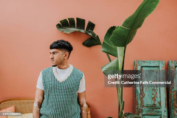 portrait of a confident, stylish young man with vitiligo - side profile - art modeling studio stock-fotos und bilder