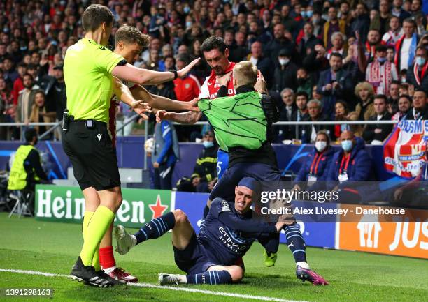 Oleksandr Zinchenko and Phil Foden of Manchester City clash with Marcos Llorente and Stefan Savic of Atletico Madrid during the UEFA Champions League...