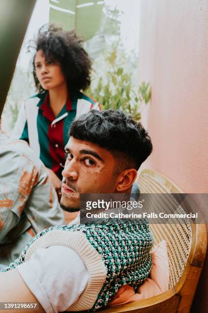 portrait of a middle-eastern man with vitiligo looks over his shoulder at the camera. - handsome middle eastern men bildbanksfoton och bilder