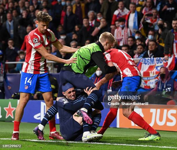 Oleksandr Zinchenko of Manchester City holds off Stefan Savic of Atletico Madrid as Phil Foden is seen on the floor during the UEFA Champions League...