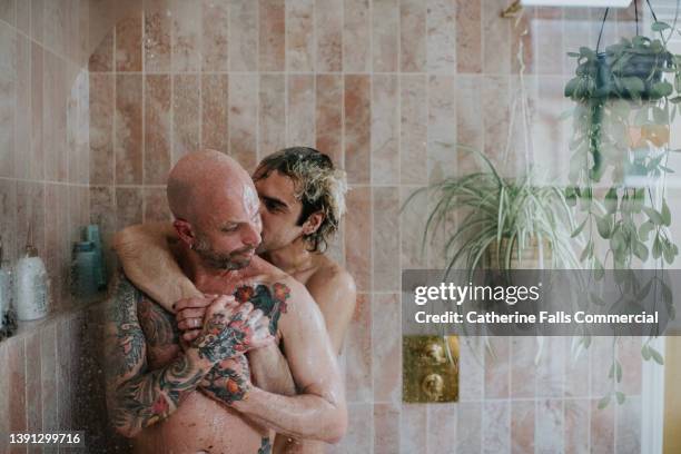 a gay couple embrace in the shower - homem banho imagens e fotografias de stock