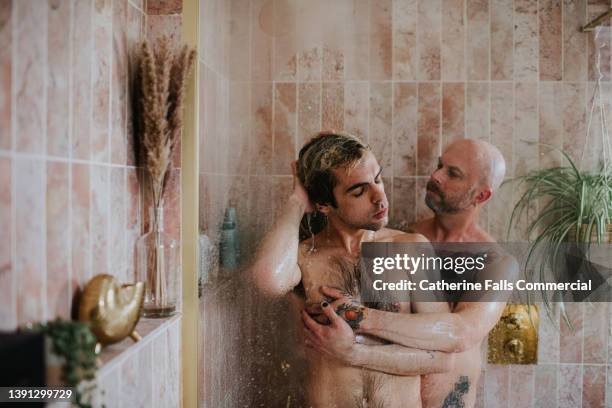 a gay couple enjoy a romantic moment in the shower - bad date stock-fotos und bilder